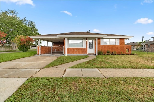 view of front of property featuring concrete driveway, fence, a front lawn, brick siding, and an attached carport