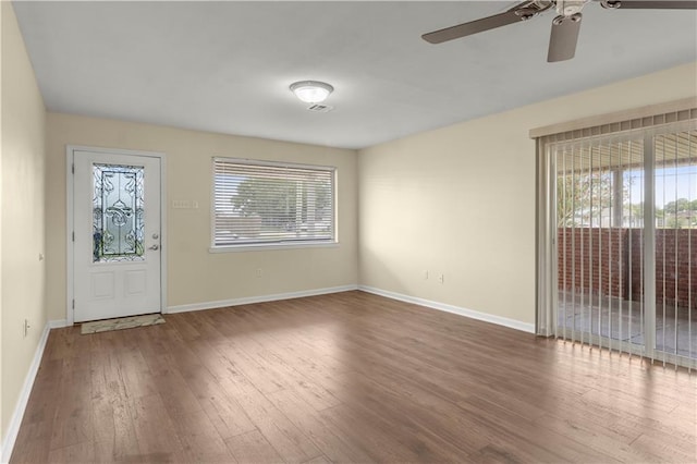 entryway with a wealth of natural light, wood finished floors, ceiling fan, and baseboards