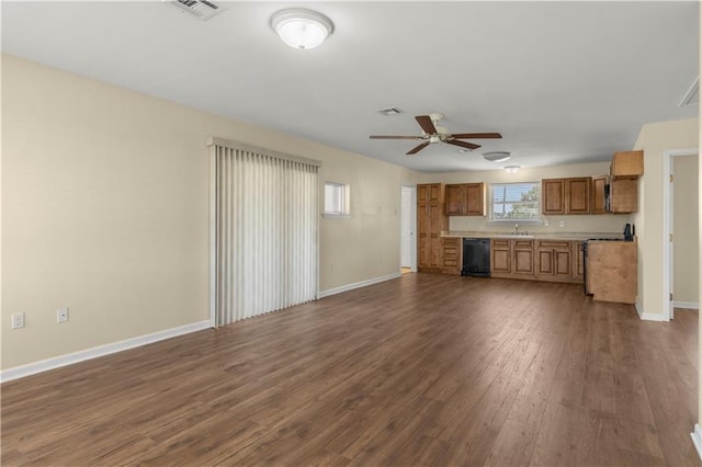 unfurnished living room with a sink, baseboards, visible vents, ceiling fan, and dark wood-type flooring