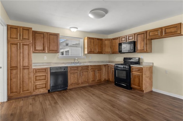 kitchen with dark hardwood / wood-style floors, sink, and black appliances