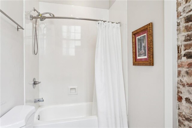 bathroom with shower / bath combo with shower curtain and toilet