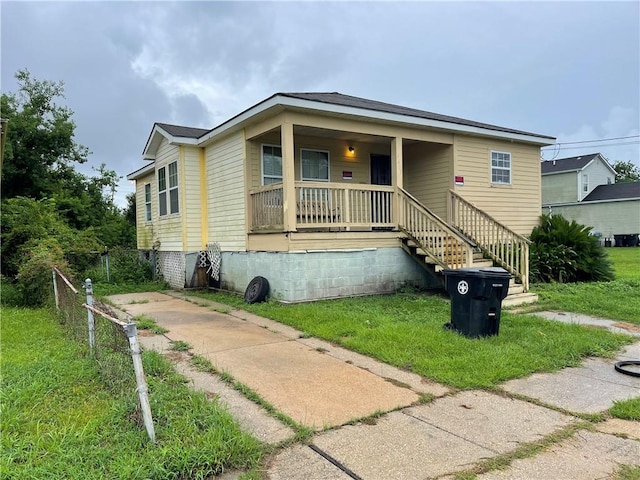 bungalow-style house with a porch and a front lawn