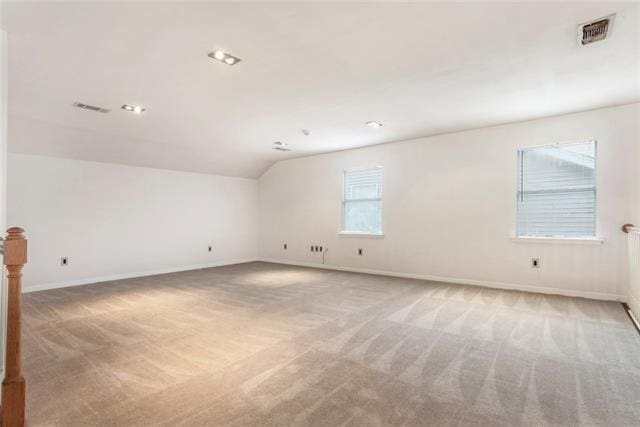 unfurnished room with light carpet and vaulted ceiling