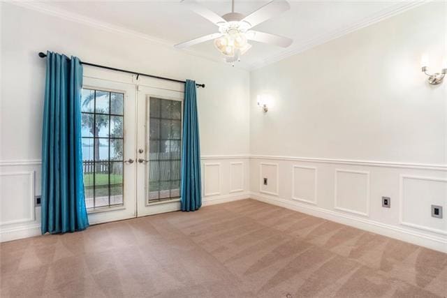 empty room with french doors, light carpet, ornamental molding, and ceiling fan