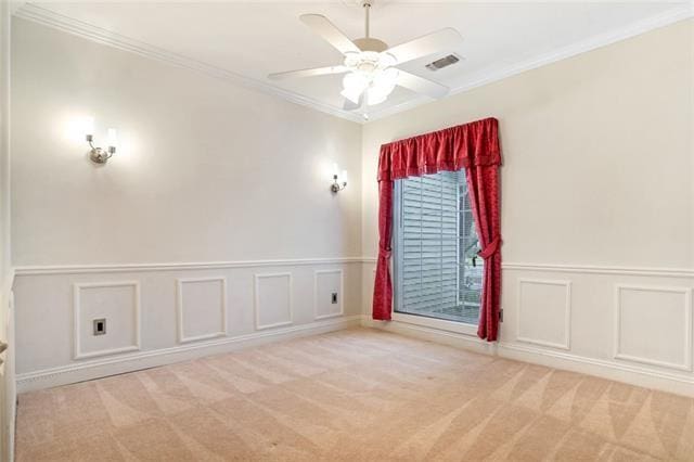 spare room featuring ornamental molding, ceiling fan, and light colored carpet