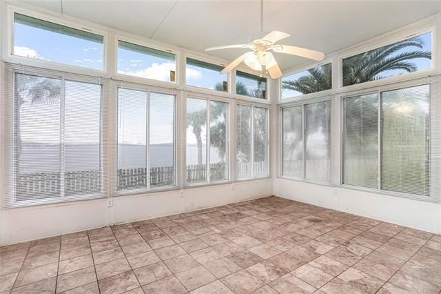 unfurnished sunroom with ceiling fan