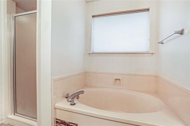 bathroom featuring independent shower and bath