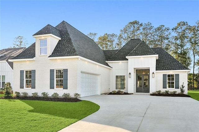 view of front of property with a garage, french doors, and a front lawn