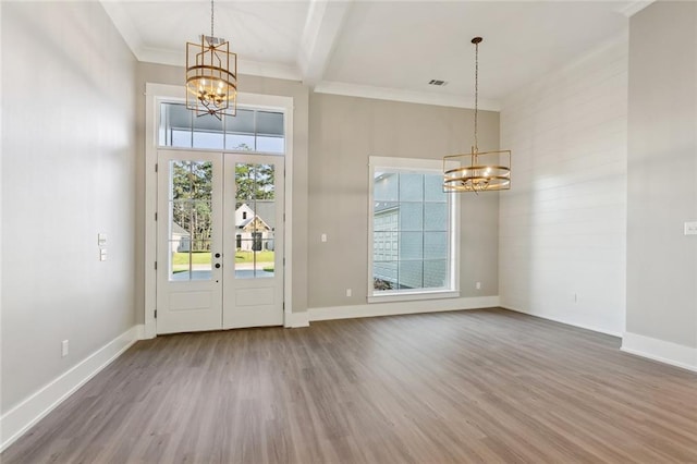 entryway with ornamental molding, french doors, wood-type flooring, and a healthy amount of sunlight