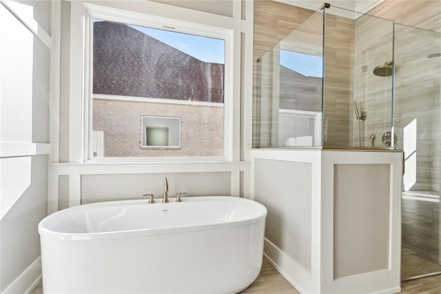 bathroom with shower with separate bathtub and hardwood / wood-style flooring