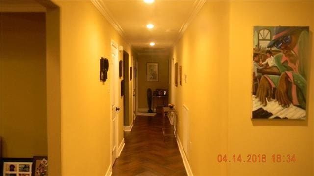 corridor featuring dark parquet floors and ornamental molding