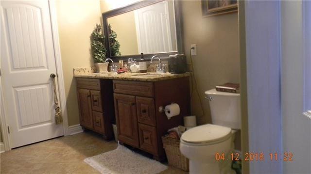 bathroom featuring tile patterned flooring, toilet, and vanity