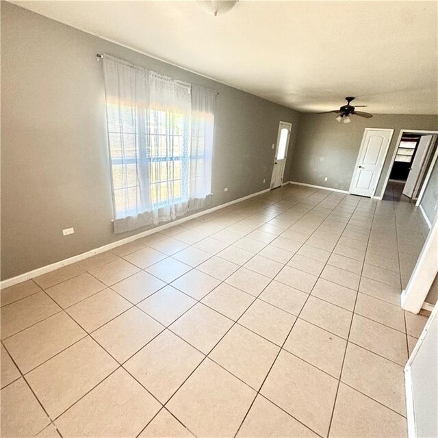 empty room featuring ceiling fan and light tile patterned floors