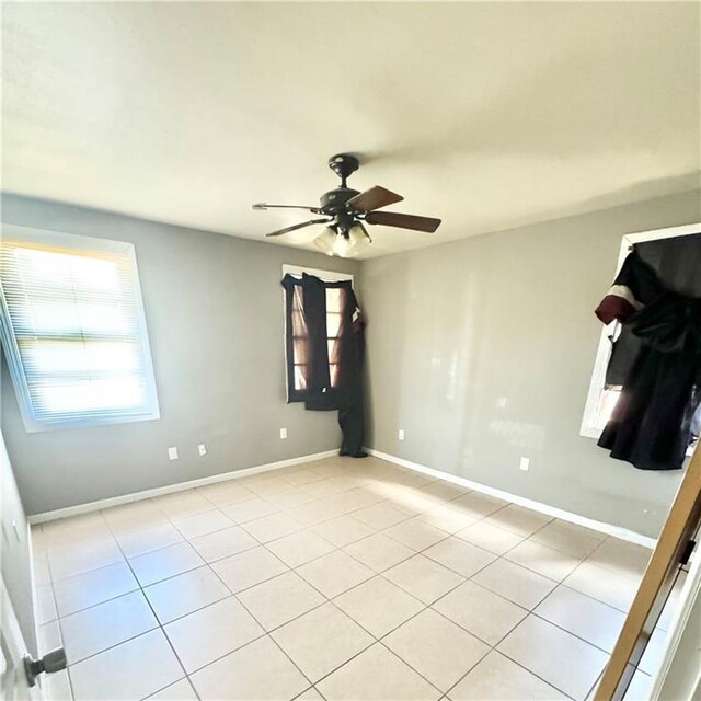 unfurnished room featuring light tile patterned floors and ceiling fan