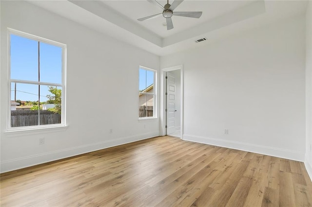 unfurnished room with ceiling fan, light wood-type flooring, and plenty of natural light