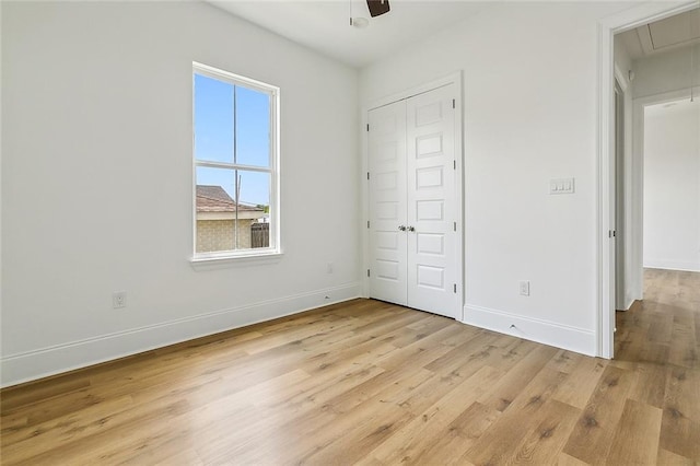 unfurnished bedroom featuring ceiling fan, light hardwood / wood-style flooring, and a closet