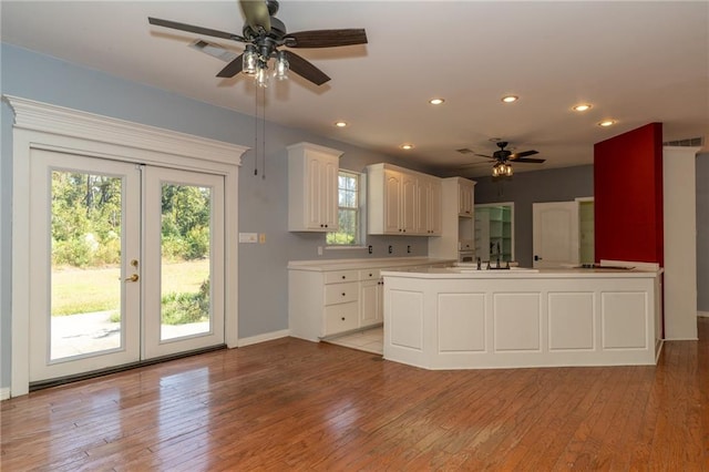 kitchen with sink, white cabinetry, light wood-type flooring, and french doors