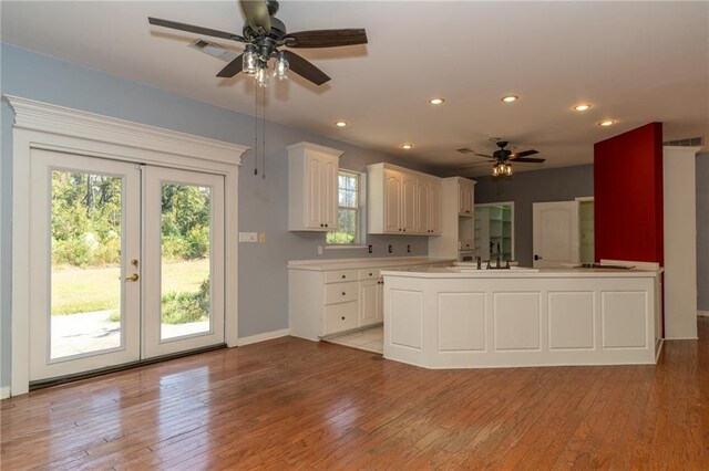 kitchen featuring tile countertops, hanging light fixtures, sink, a center island, and ceiling fan with notable chandelier