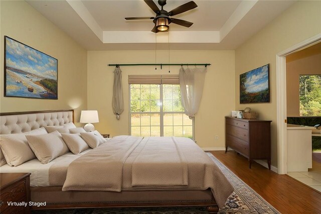 sitting room with wood-type flooring and a tray ceiling