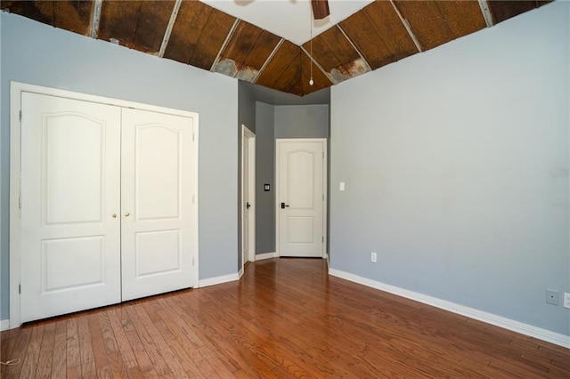 unfurnished bedroom featuring hardwood / wood-style floors, a closet, ceiling fan, wooden ceiling, and vaulted ceiling