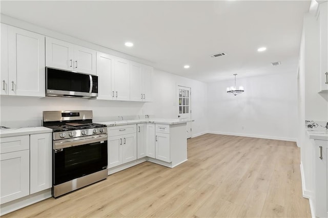 kitchen featuring an inviting chandelier, decorative light fixtures, appliances with stainless steel finishes, light hardwood / wood-style floors, and white cabinetry