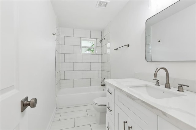 full bathroom with tile patterned flooring, toilet, tiled shower / bath combo, and vanity