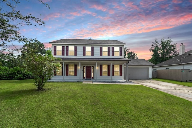 colonial inspired home featuring a lawn, a porch, and a garage