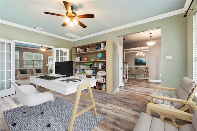 home office with french doors, ceiling fan with notable chandelier, light hardwood / wood-style flooring, and crown molding