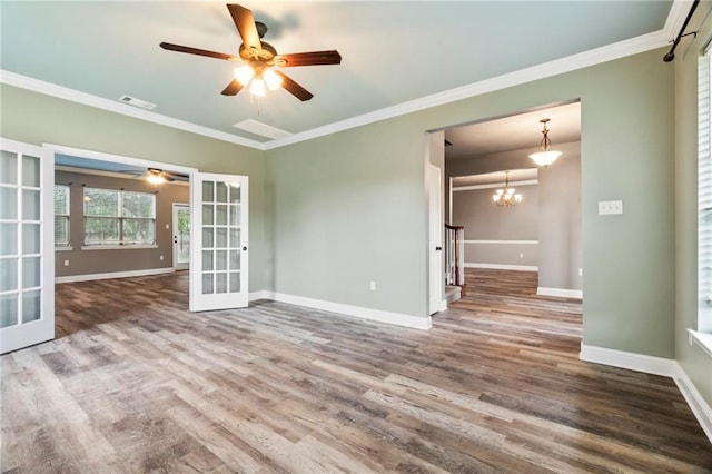 unfurnished room featuring french doors, ornamental molding, ceiling fan with notable chandelier, and hardwood / wood-style flooring