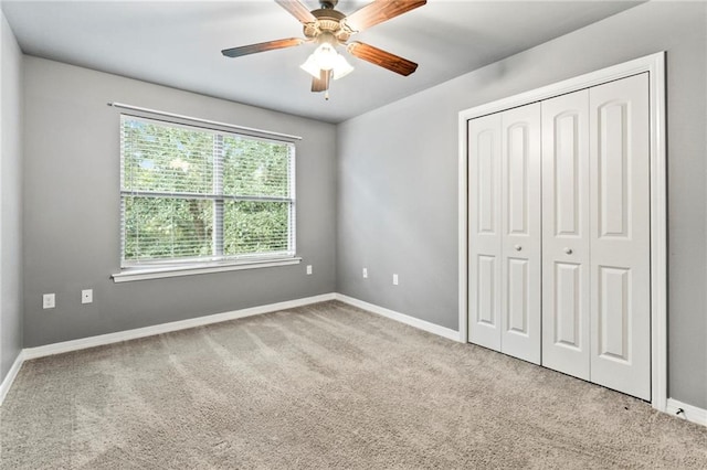 unfurnished bedroom featuring a closet, light colored carpet, and ceiling fan