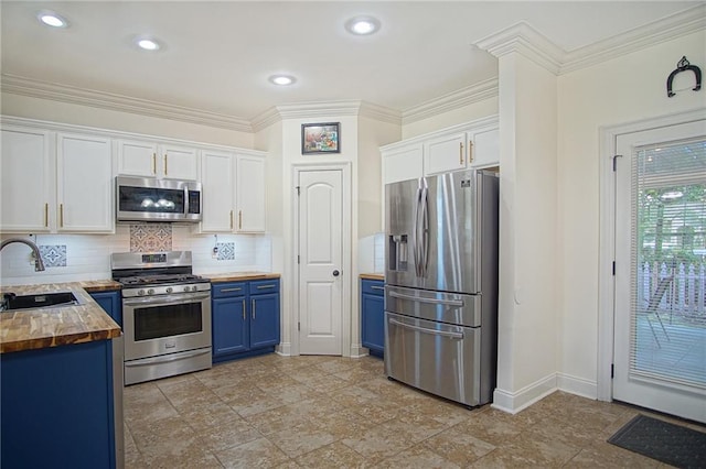 kitchen featuring white cabinetry, stainless steel appliances, wooden counters, and blue cabinetry