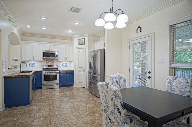 kitchen featuring blue cabinetry, butcher block counters, white cabinetry, decorative light fixtures, and stainless steel appliances