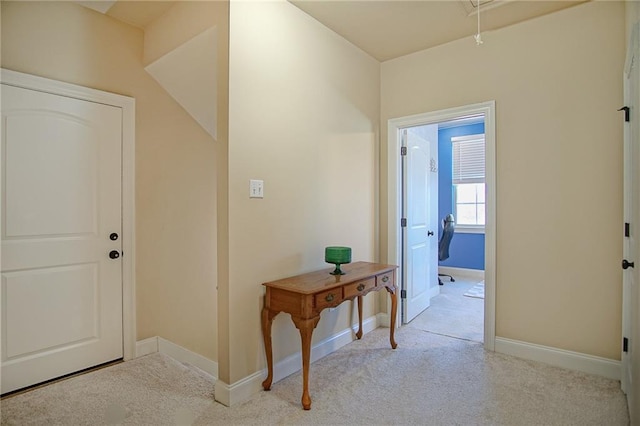 hallway featuring light colored carpet