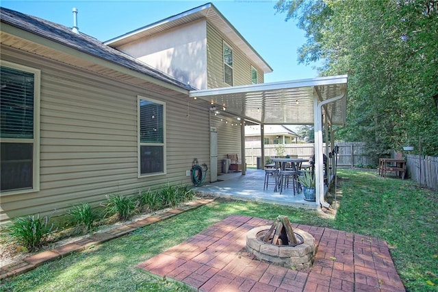 back of house featuring a patio, a yard, and a fire pit