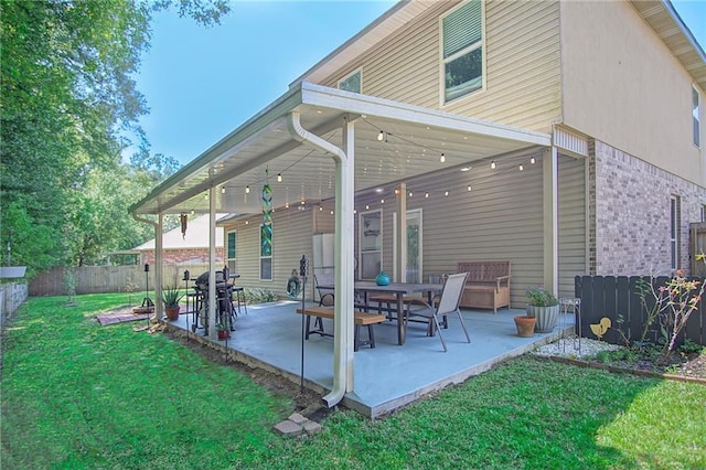 rear view of property featuring a patio and a lawn