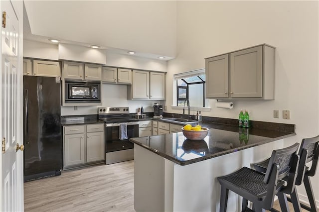 kitchen featuring black appliances, kitchen peninsula, gray cabinetry, and sink