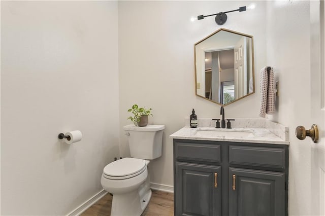 bathroom with vanity, toilet, and hardwood / wood-style floors