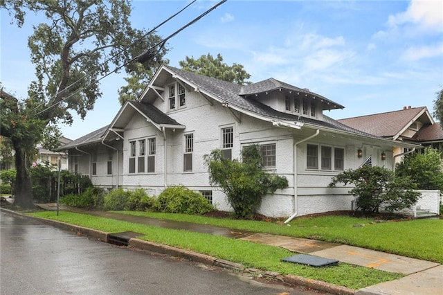 view of side of home with a yard