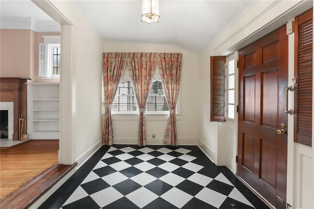 entryway featuring lofted ceiling, crown molding, dark hardwood / wood-style floors, and a tile fireplace