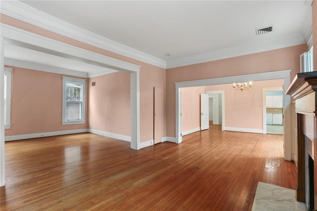 unfurnished living room featuring a high end fireplace, crown molding, wood-type flooring, and a notable chandelier