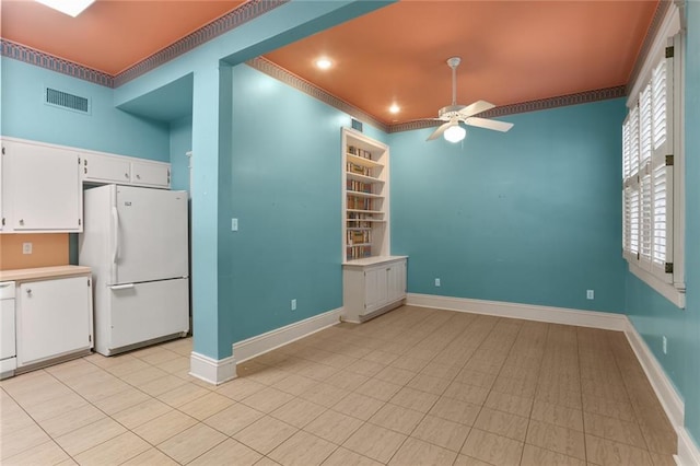 interior space with white cabinetry, ceiling fan, and white fridge