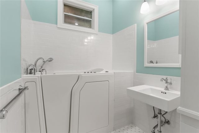 bathroom featuring tile walls and a tub to relax in