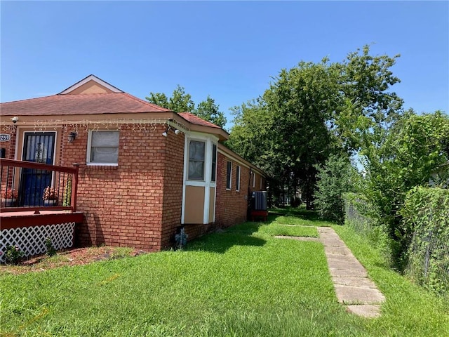 view of property exterior featuring a deck, a lawn, and cooling unit