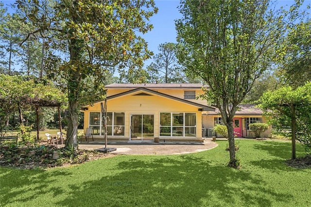 rear view of property featuring a yard, a patio, and central AC