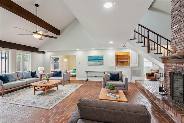 living room featuring ceiling fan, lofted ceiling with beams, and a fireplace