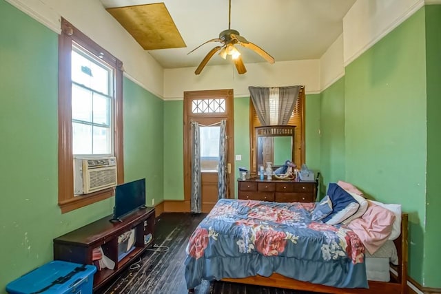 bedroom featuring ceiling fan, multiple windows, cooling unit, and wood finished floors