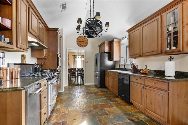 kitchen featuring vaulted ceiling, stainless steel appliances, a notable chandelier, sink, and dark stone counters