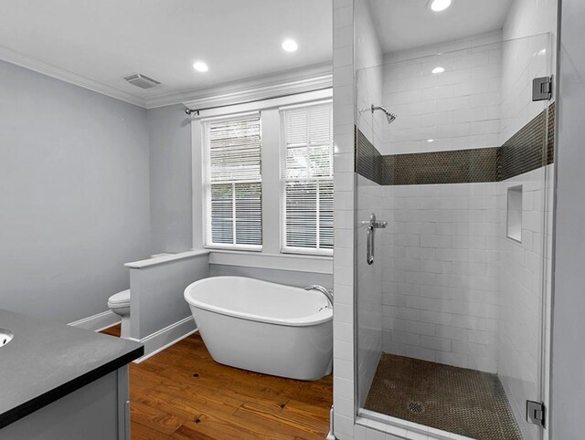 full bathroom with hardwood / wood-style floors, vanity, independent shower and bath, and ornamental molding