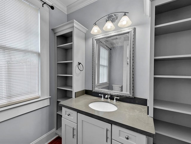 bathroom with crown molding, vanity, and toilet