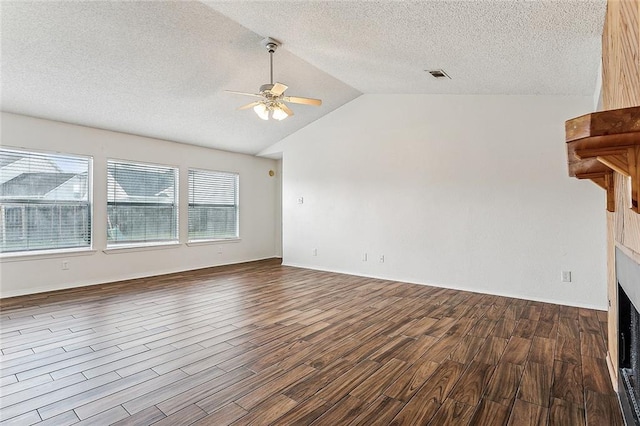 unfurnished living room featuring vaulted ceiling, a textured ceiling, hardwood / wood-style floors, and ceiling fan